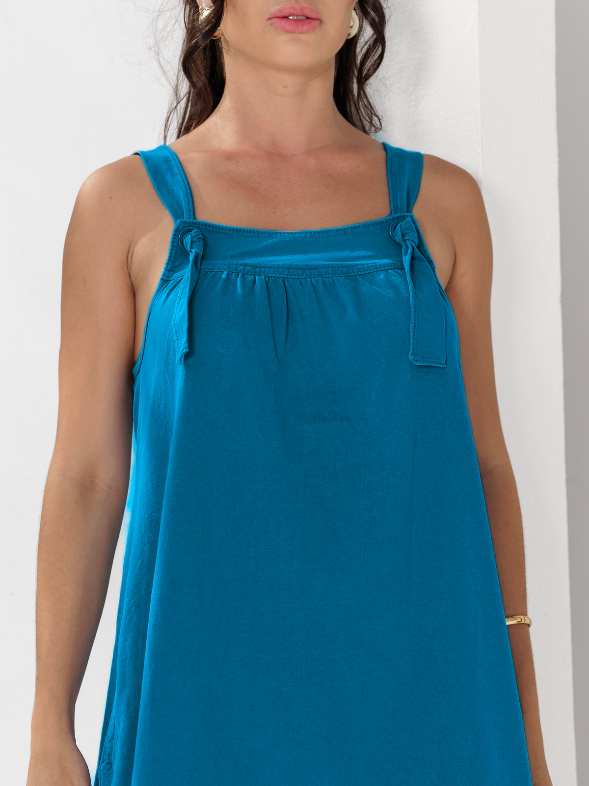Modelo veste Vestido Sarah Azul Profundo em 100% algodão, com alças ajustáveis em ilhós e caimento fluido